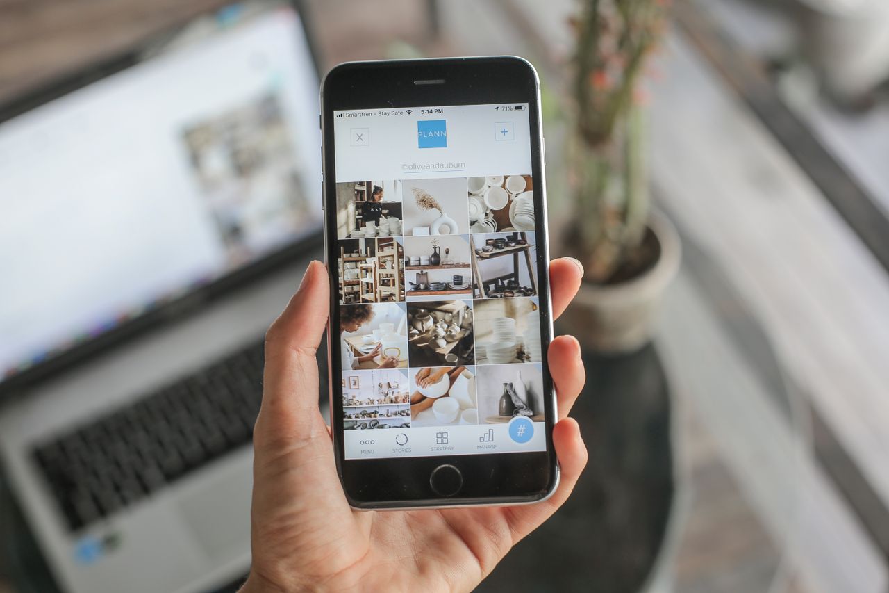 Close-up of a woman using a social media app on a smartphone indoors, showcasing technology in daily life.